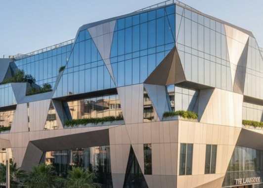 Κτίριο με γυάλινη πρόσοψη και γεωμετρικά πάνελ